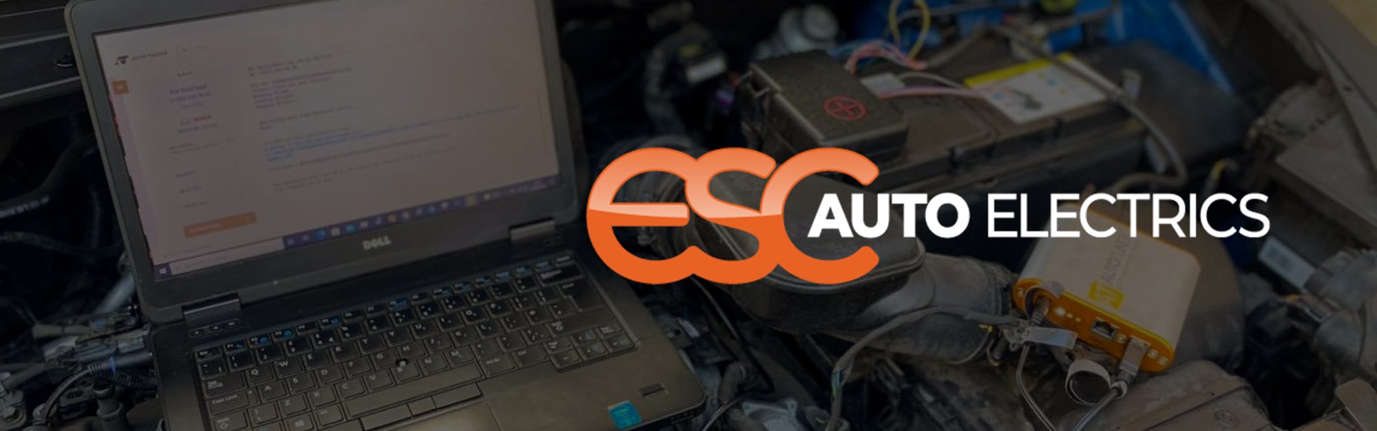ESC Auto Electrics' logo laid over a darkened image of a laptop on an engine area of a car having diagnostics work done.